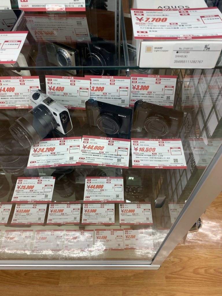 ショーケースに並ぶ中古カメラと複数の値札