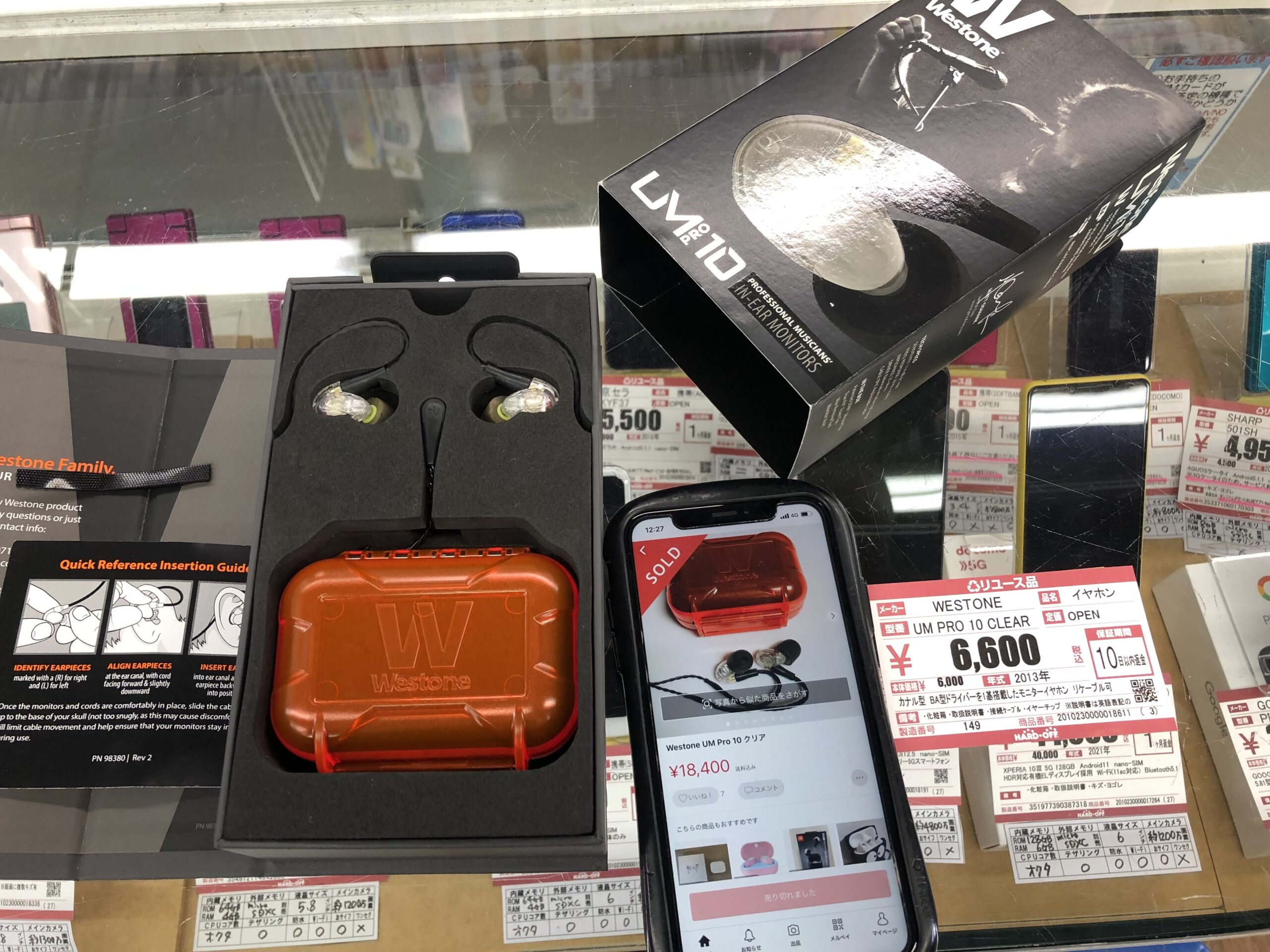 中古商品の型番と販売相場をスマートフォンで照合している様子